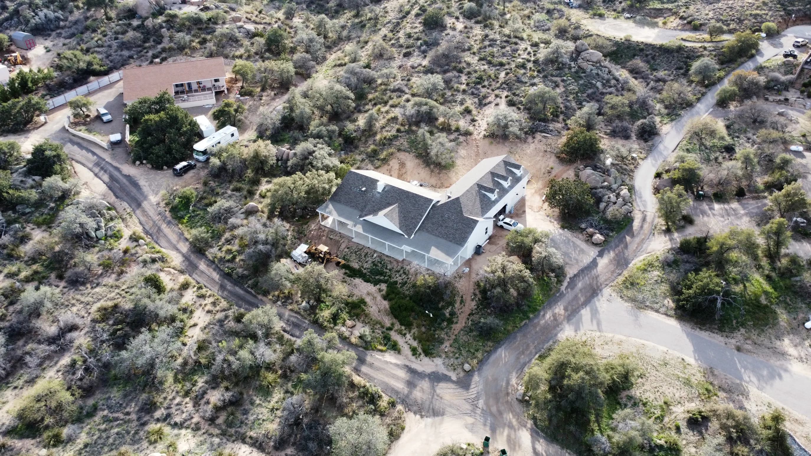Coronado crew working ridge-cap detail on a steep custom new-build in Oracle, AZ